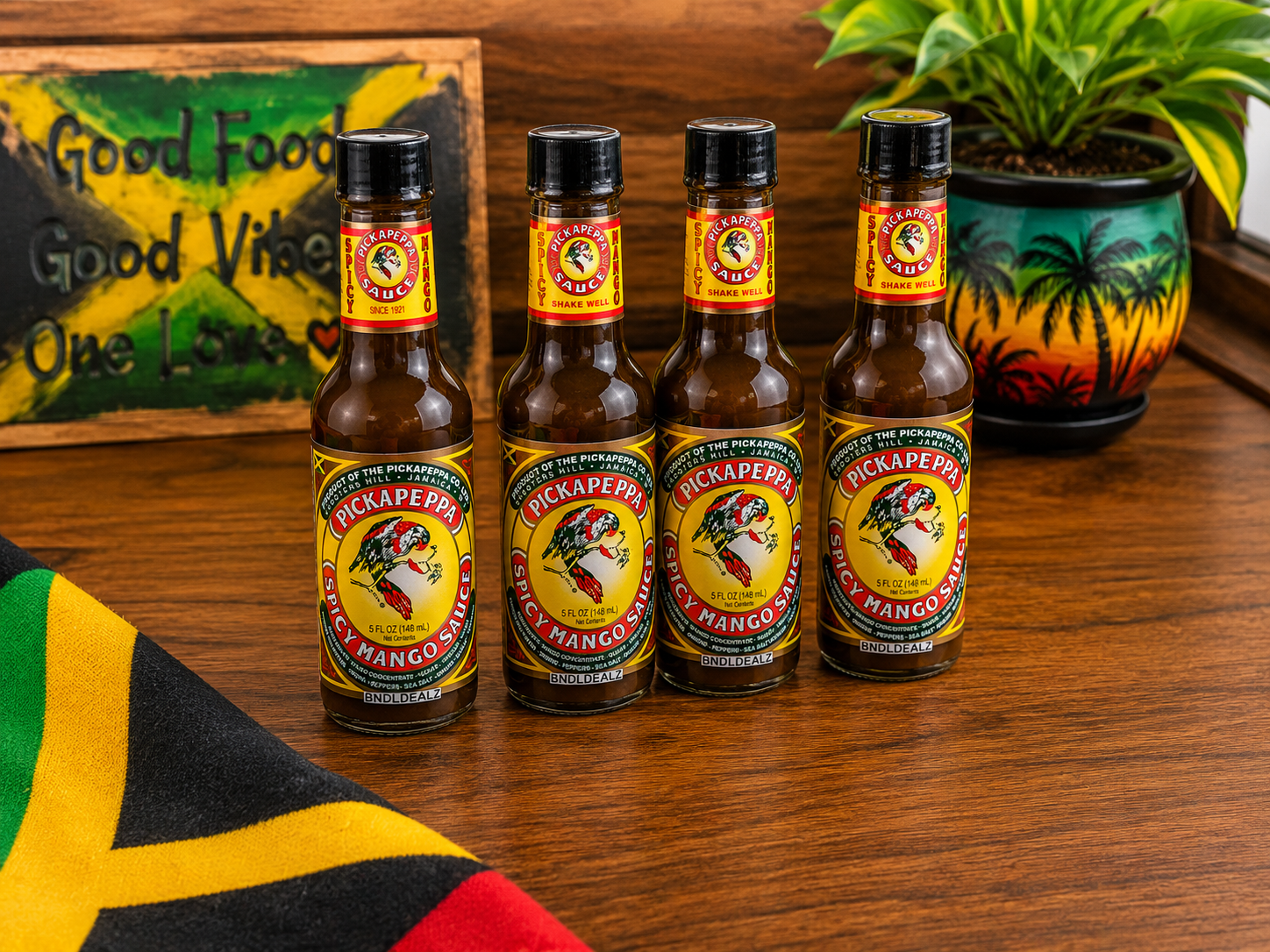 Pickapeppa Spicy Mango Sauce 4 Pack displayed in a Jamaican-inspired kitchen setting with tropical décor.